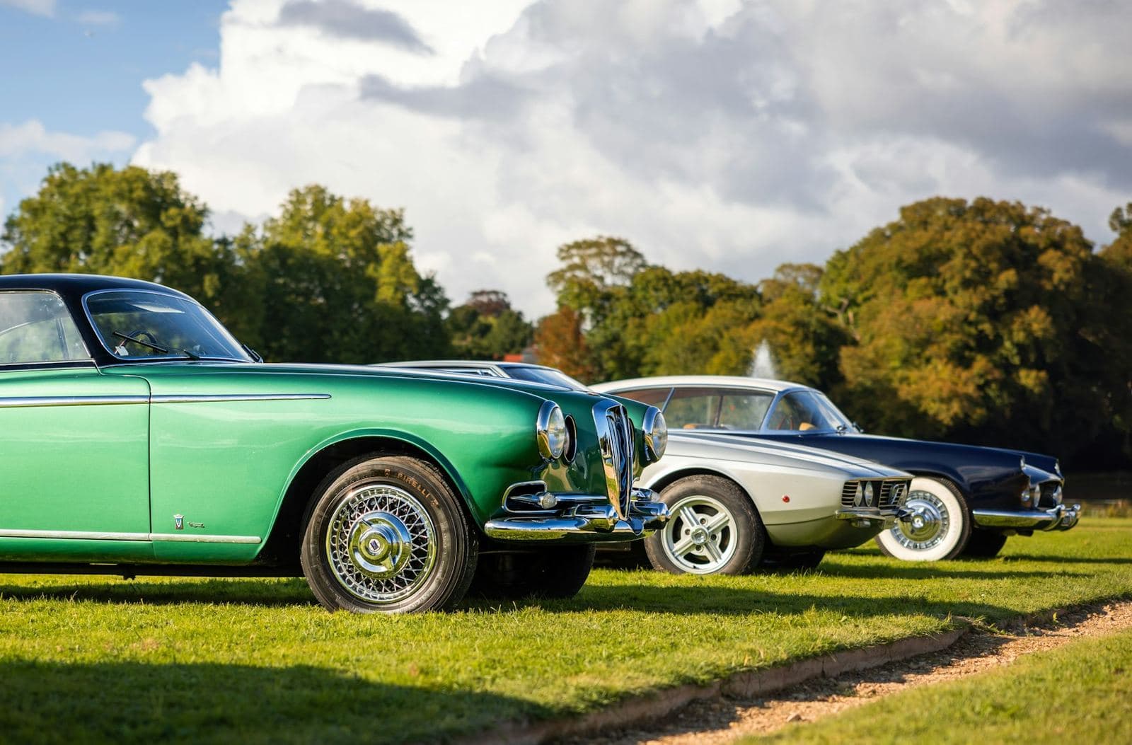 Classic coupés lined up on the lawn at a concours car show
